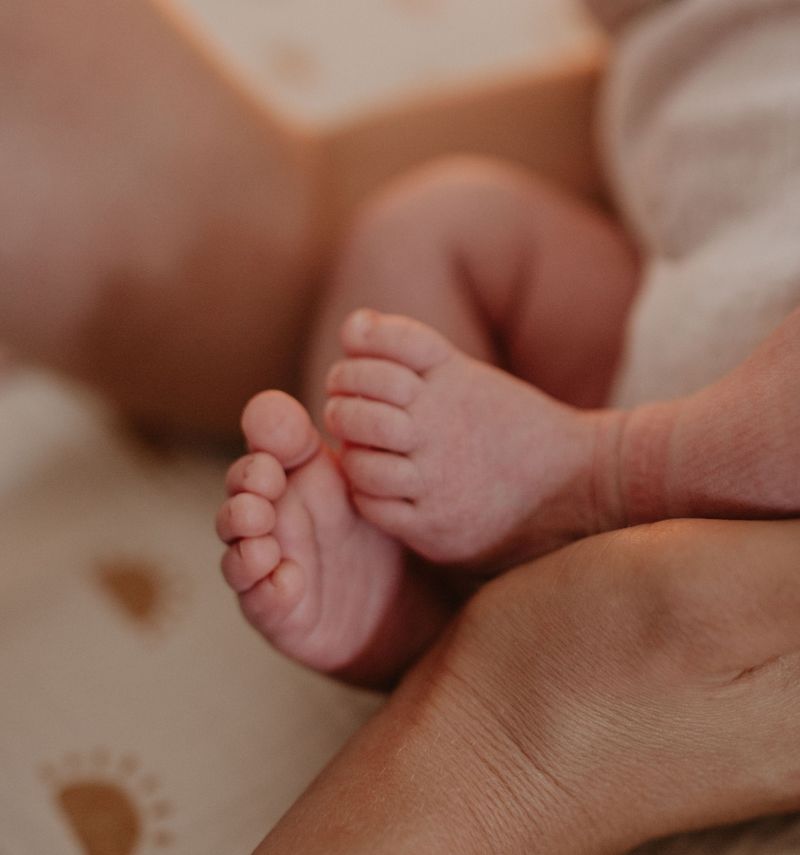 Baby Füße, gehalten von der Mutter